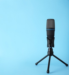 Professional condenser microphone on color background, space for text