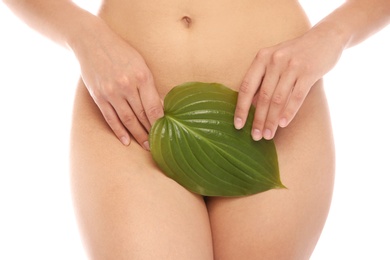Photo of Young woman with leaf showing smooth skin after bikini epilation on white background
