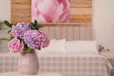 Bouquet of beautiful hydrangea flowers on table in bedroom, space for text. Interior design