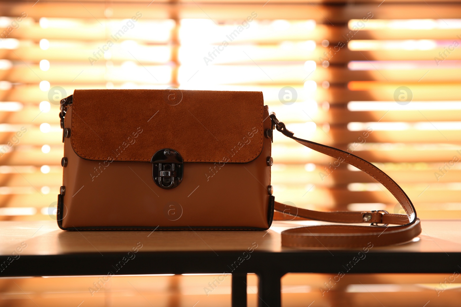 Photo of Stylish woman's bag on shelf in boutique