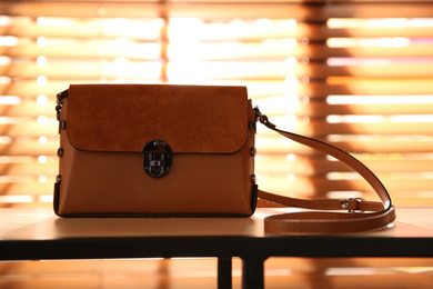 Photo of Stylish woman's bag on shelf in boutique