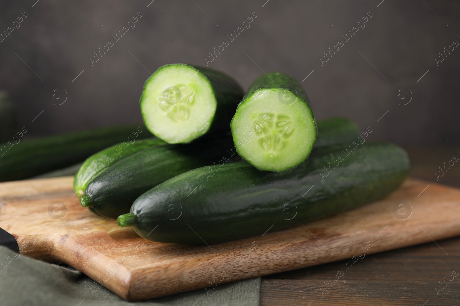 Photo of Many fresh cucumbers on wooden table, closeup