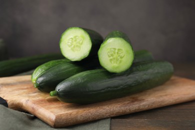 Photo of Many fresh cucumbers on wooden table, closeup