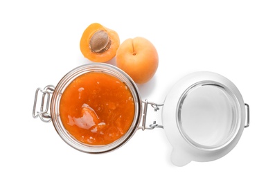 Photo of Jar with delicious apricot jam and fruit on white background