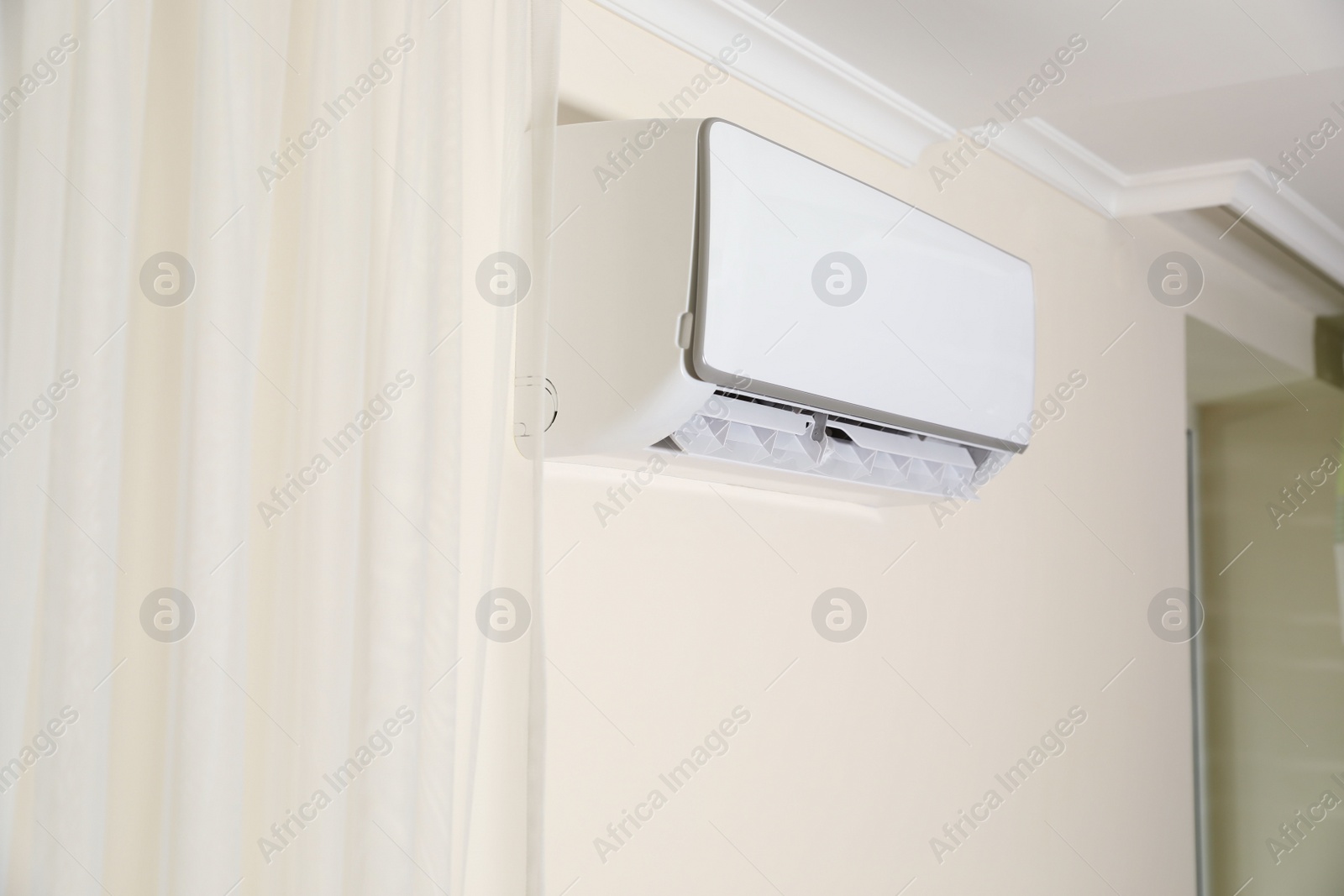 Photo of Modern air conditioner on white wall indoors