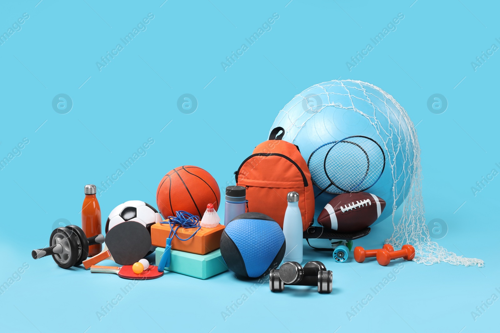 Photo of Many different sports equipment on light blue background