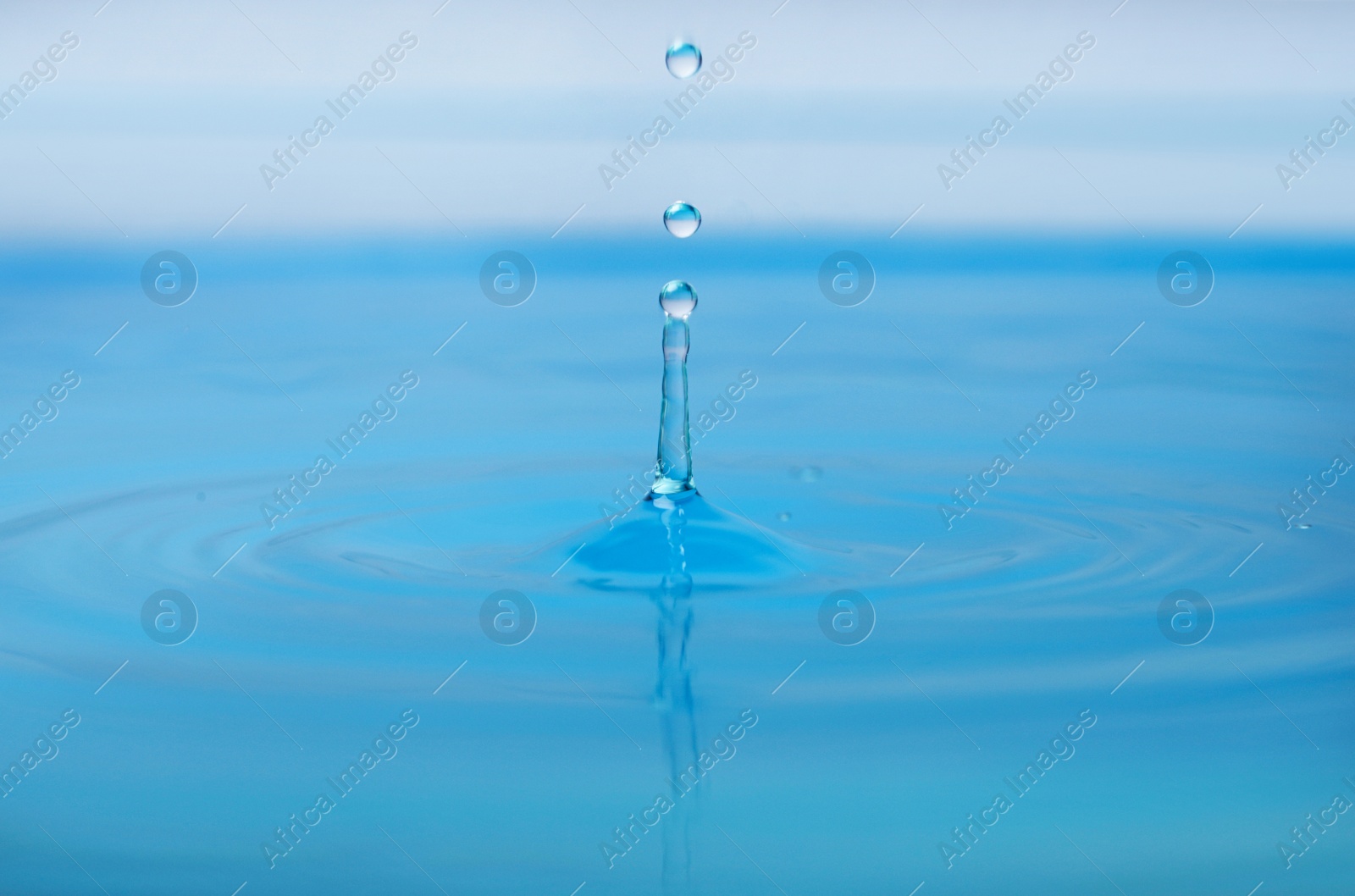 Photo of Splash of blue water with drop, closeup