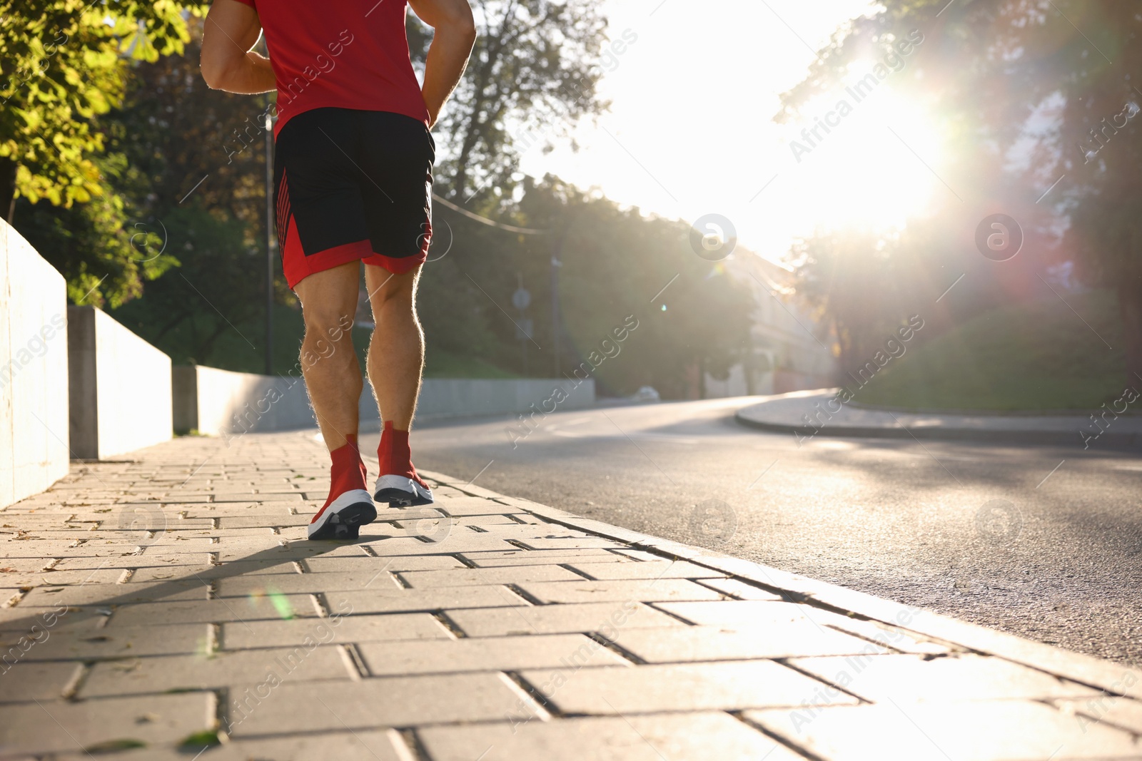 Photo of Man running outdoors on sunny day, closeup. Space for text