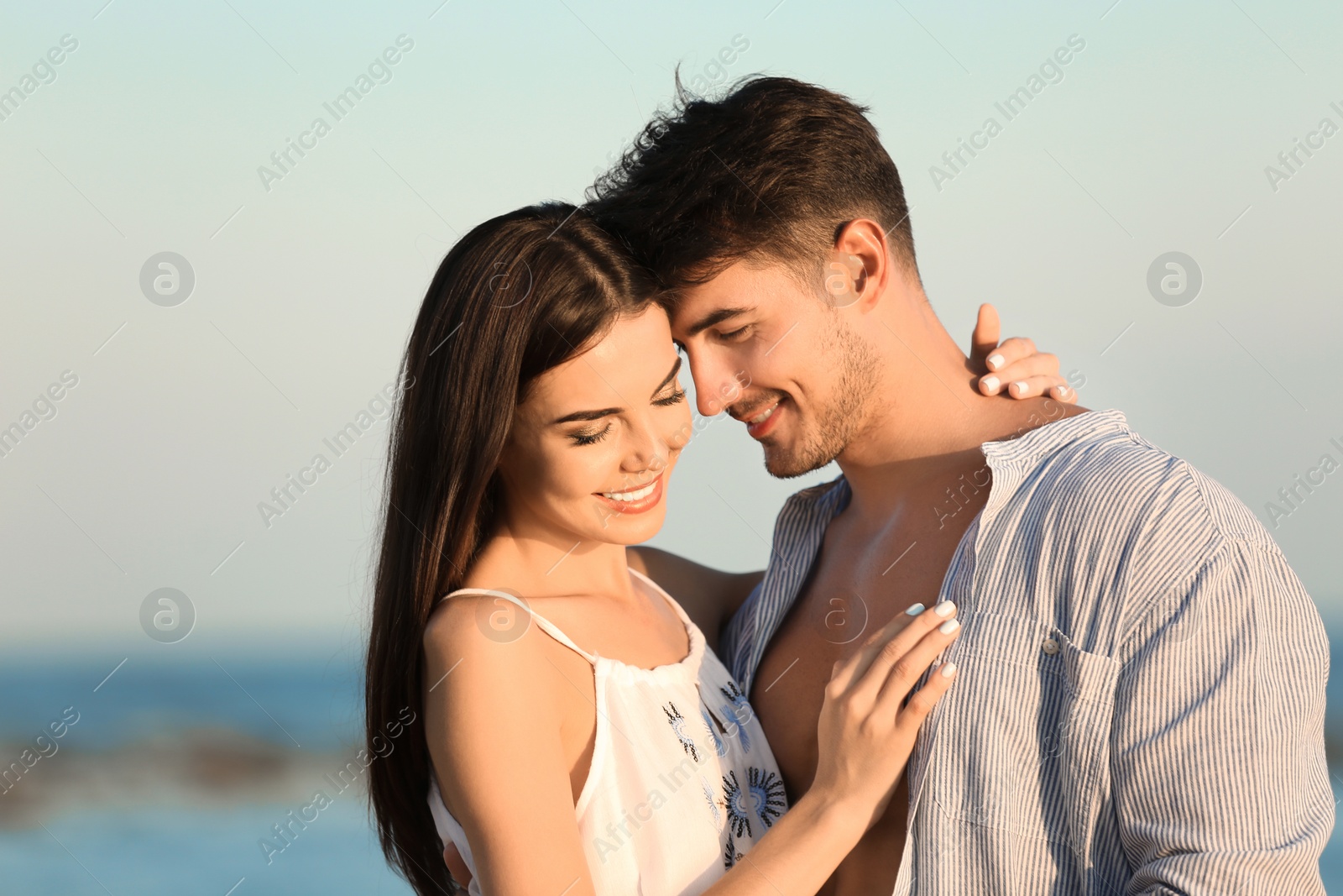 Photo of Happy young couple posing near sea on beach