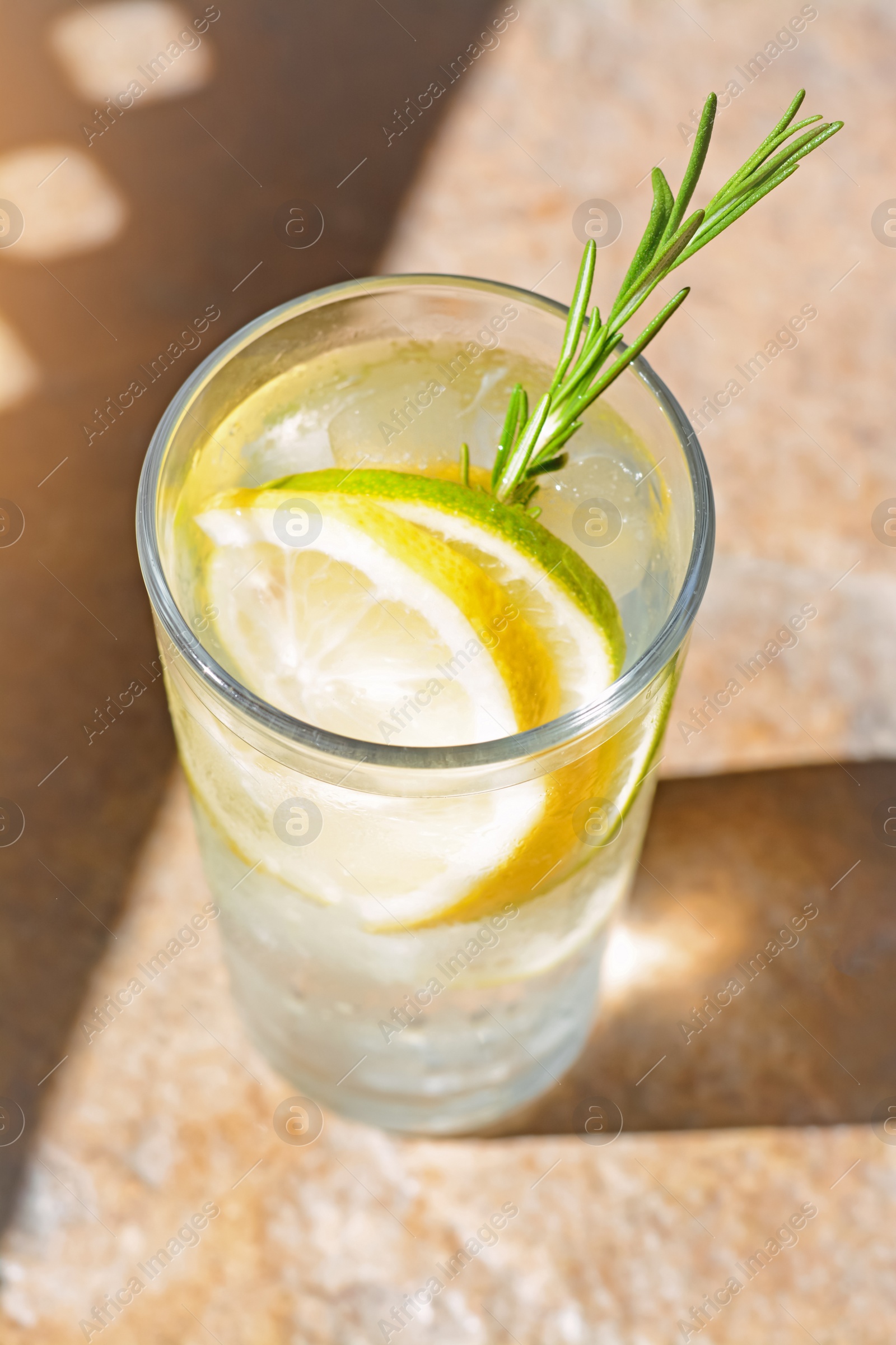 Photo of Summer refreshing lemonade on light brown table, closeup