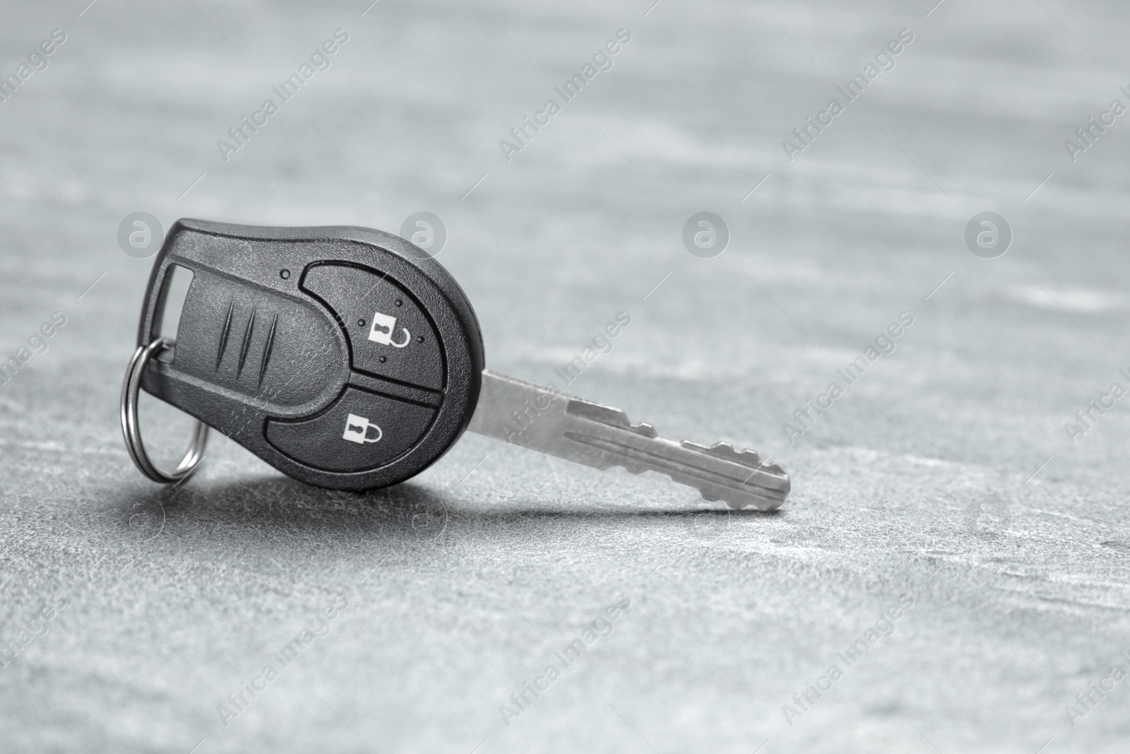 Photo of Car key on grey background. Space for text