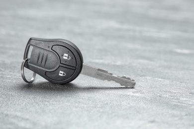 Car key on grey background. Space for text