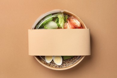 Tasty food in container on beige background, top view. Space for text