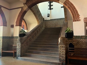 Photo of School hallway interior with arch above stone staircase