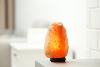 Himalayan salt lamp on table indoors, space for text