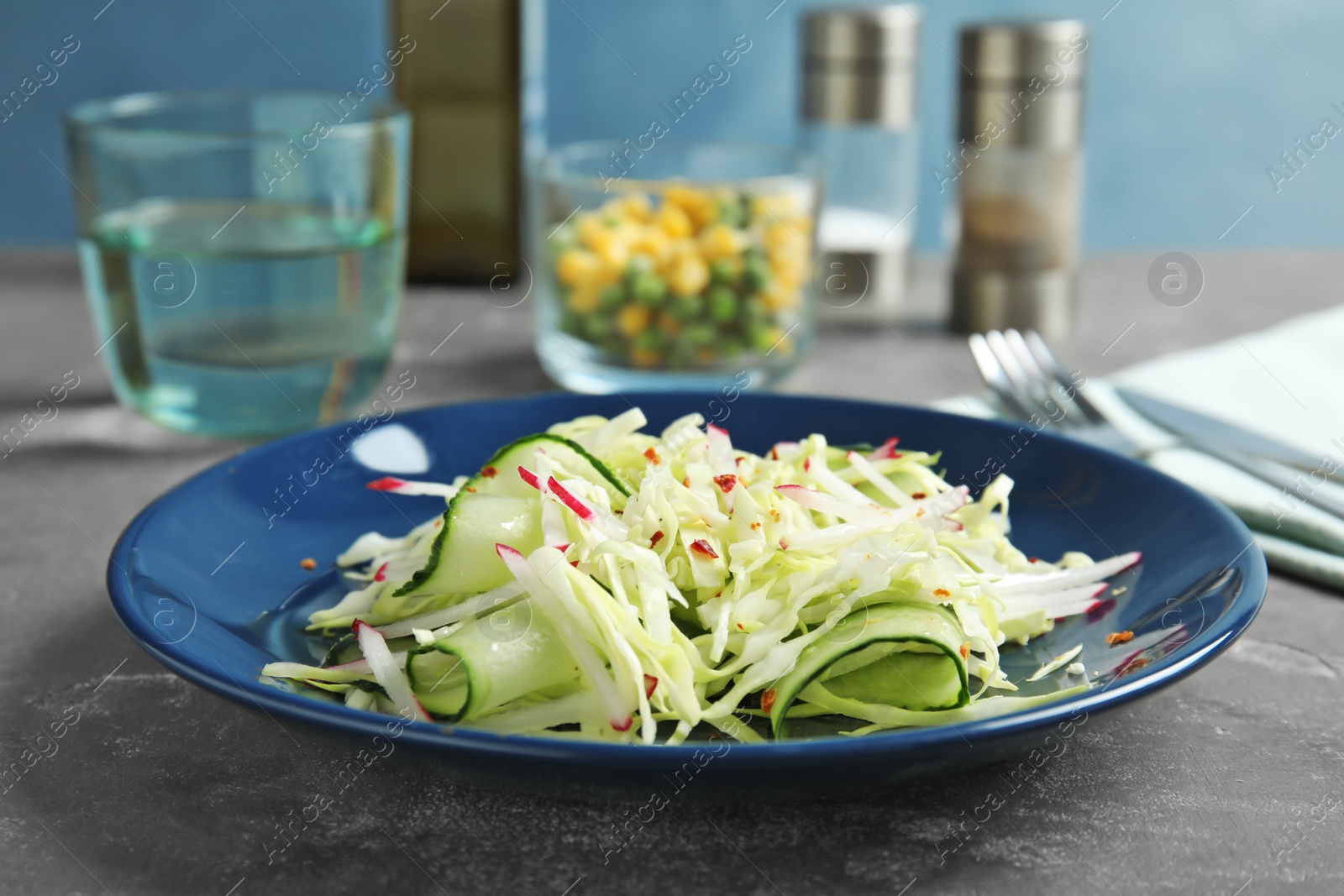 Photo of Plate with healthy cabbage salad on dark table