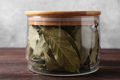 Photo of Bay leaves in glass jar on wooden table