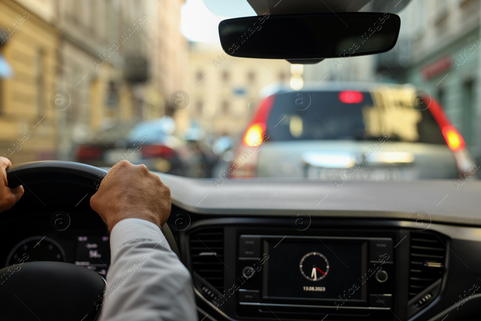 Photo of Stuck in traffic jam. Driver holding hands on steering wheel in car, closeup