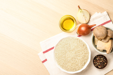 Photo of Flat lay composition with different ingredients on wooden table, space for text. Risotto recipe