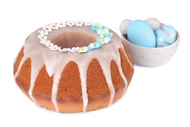 Festively decorated Easter cake and painted eggs on white background