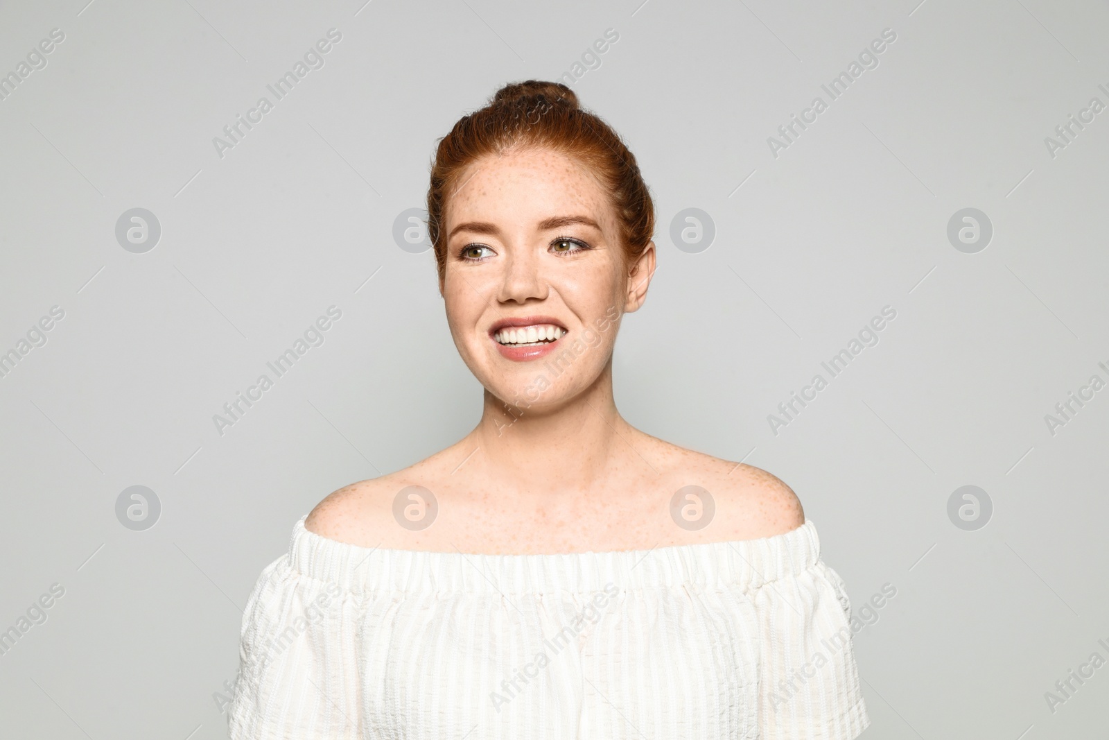 Photo of Portrait of young woman with beautiful face on grey background