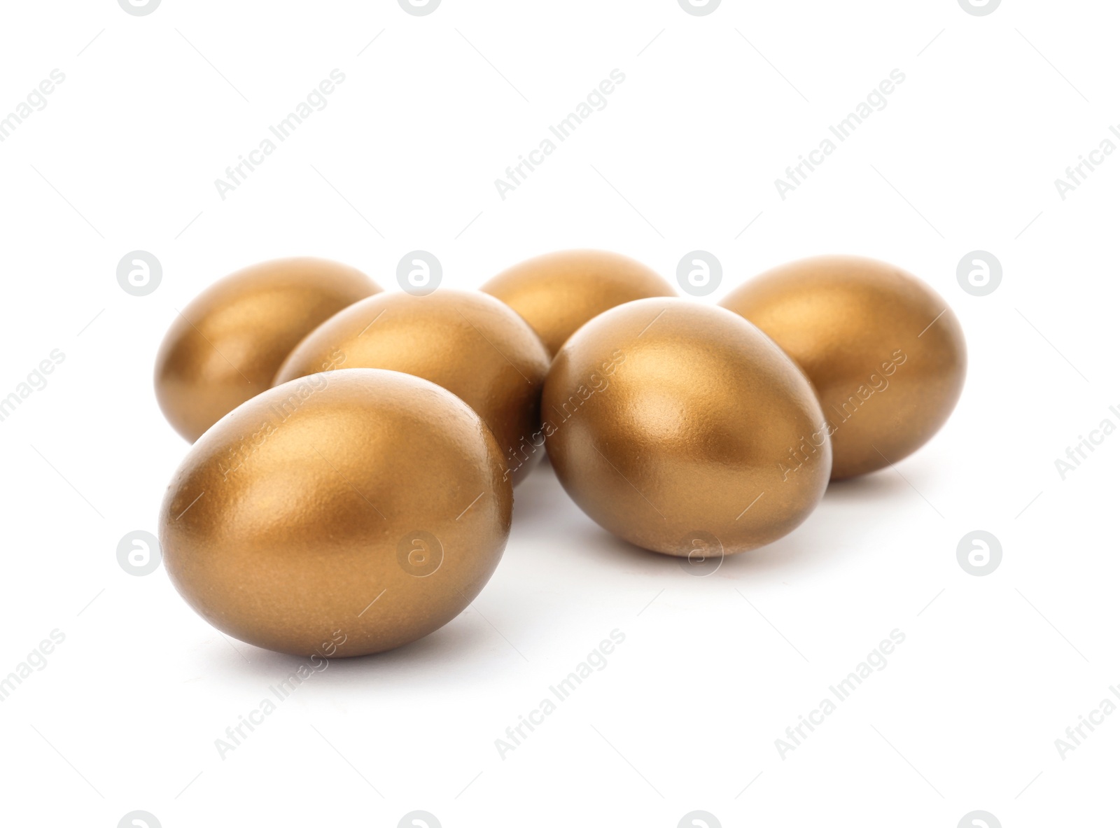 Photo of Many shiny golden eggs on white background