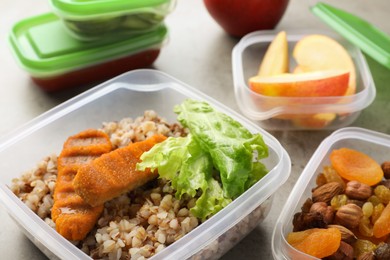 Photo of Set of plastic containers with fresh food on light grey table, closeup