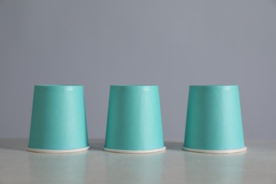 Photo of Shell game. Three paper cups on light table