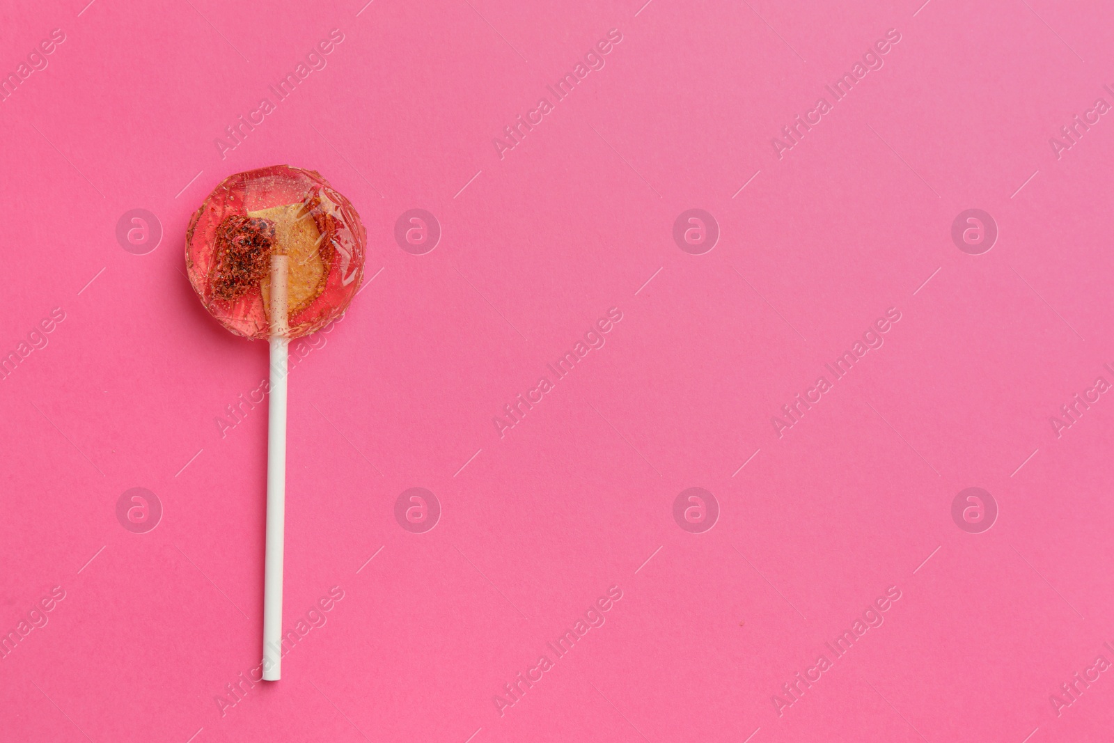 Photo of Sweet colorful lollipop with berries on pink background, top view. Space for text