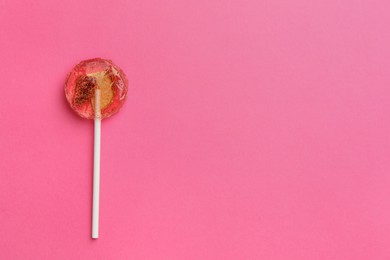 Photo of Sweet colorful lollipop with berries on pink background, top view. Space for text