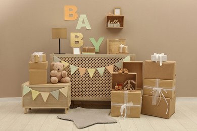 Gift boxes and toys in room decorated for baby shower party