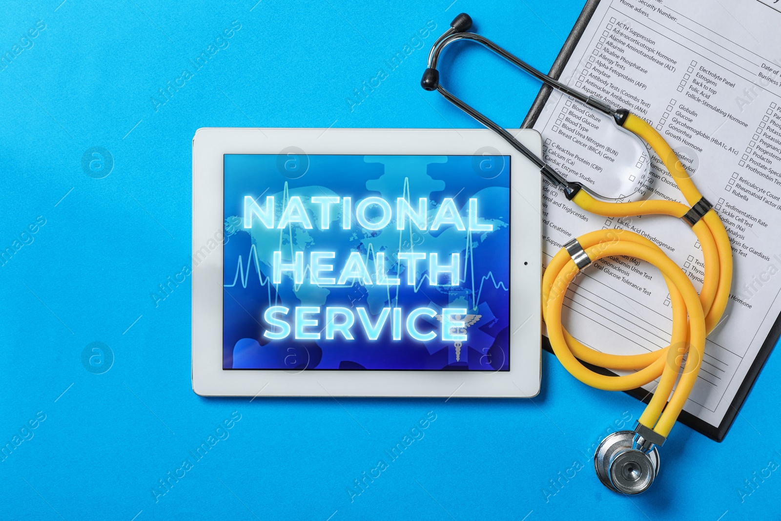 Image of National health service (NHS). Tablet with text, stethoscope and test form on light blue background, flat lay