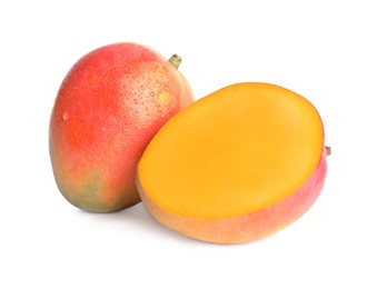 Delicious whole and cut mangoes on white background