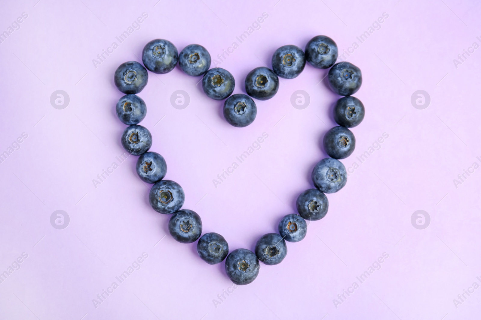 Photo of Heart of fresh ripe blueberries on lilac background, flat lay