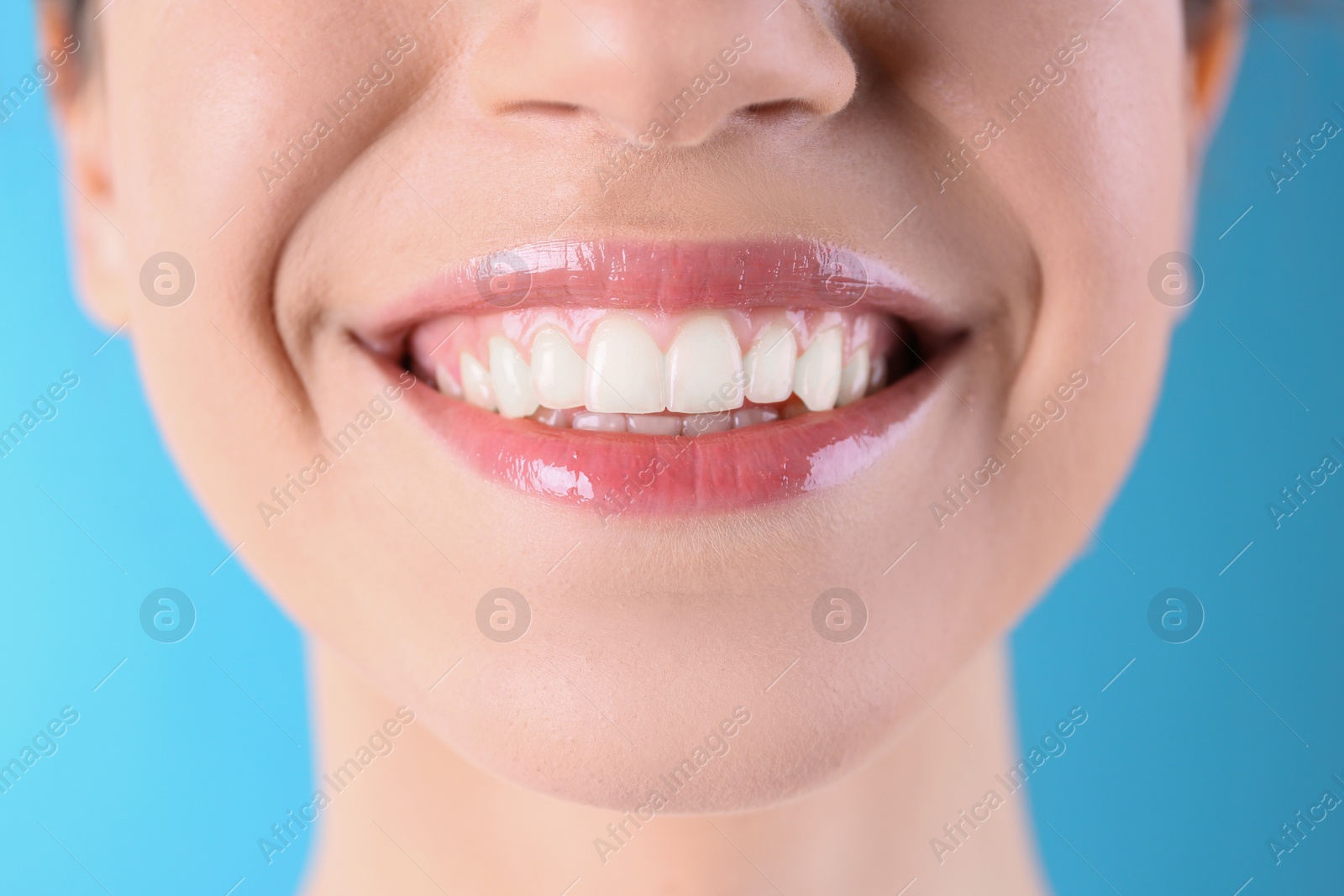 Photo of Young woman with healthy teeth and beautiful smile on color background, closeup