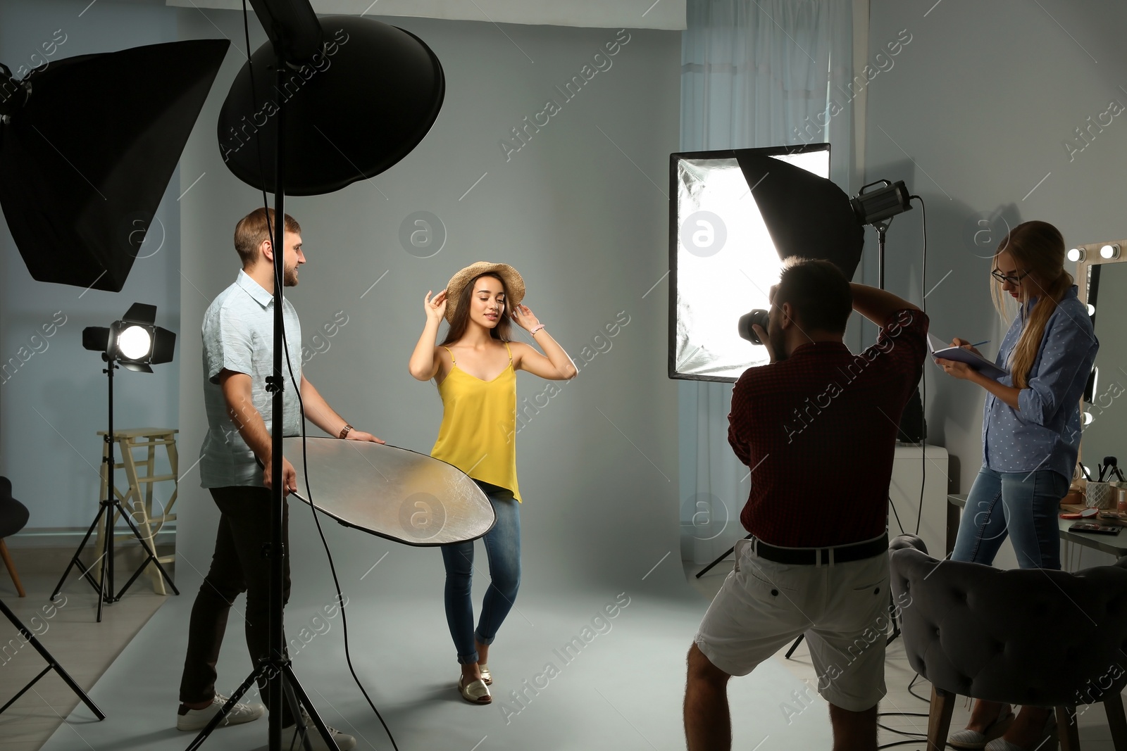 Photo of Professional team working with model in photo studio