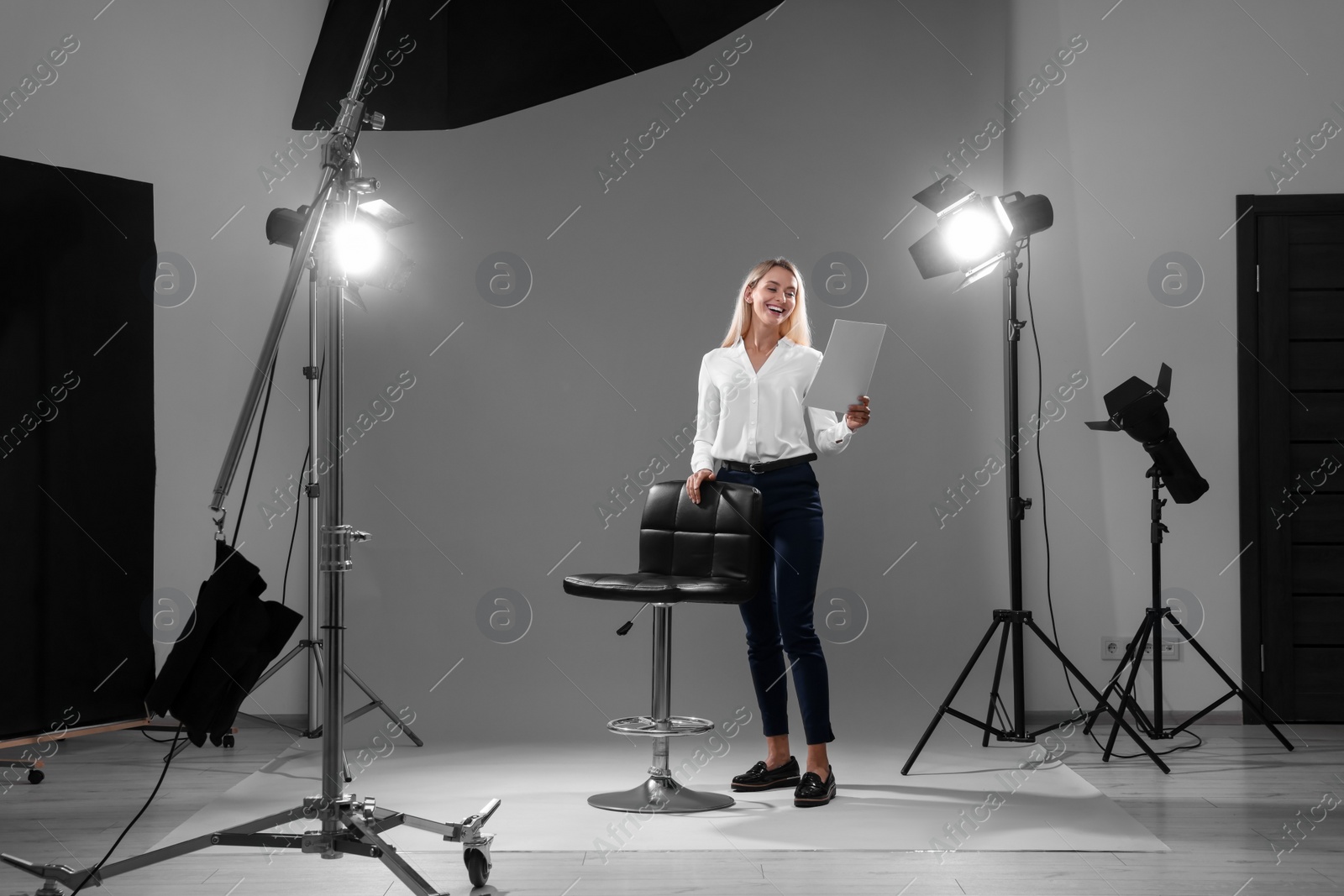 Photo of Casting call. Emotional woman performing against grey background in studio