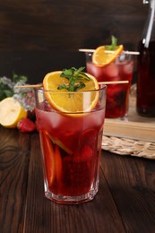 Photo of Glasses of delicious refreshing sangria on wooden table