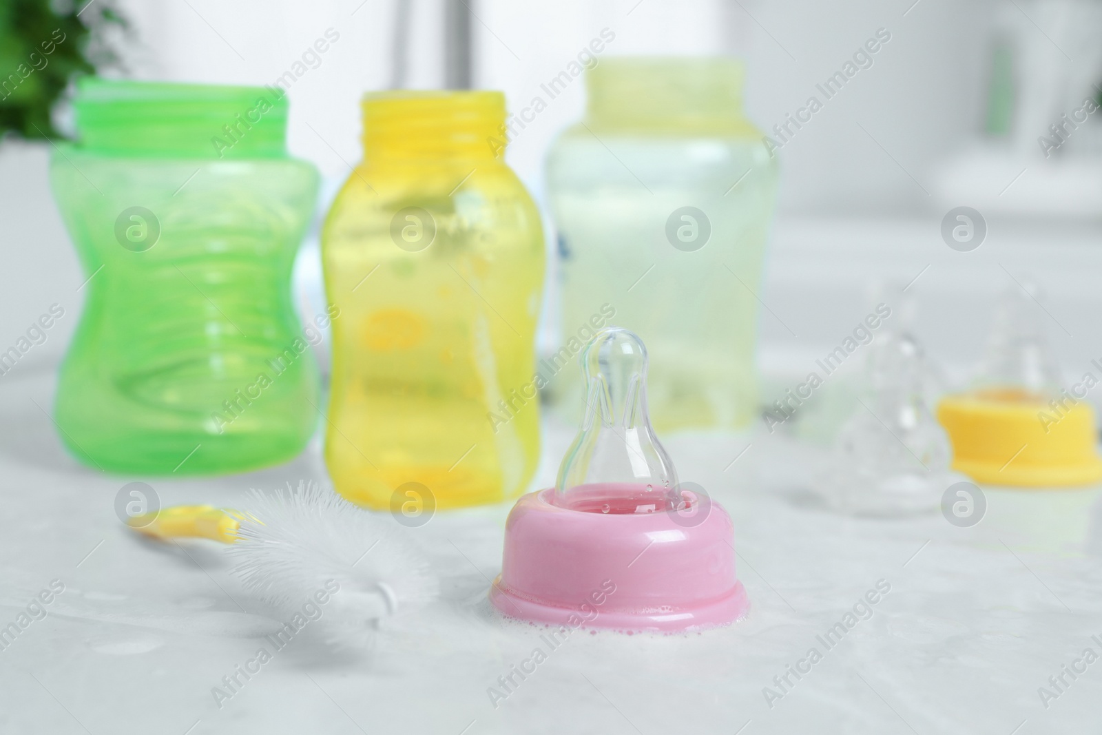 Photo of Baby bottles and nipples after washing on white countertop in kitchen