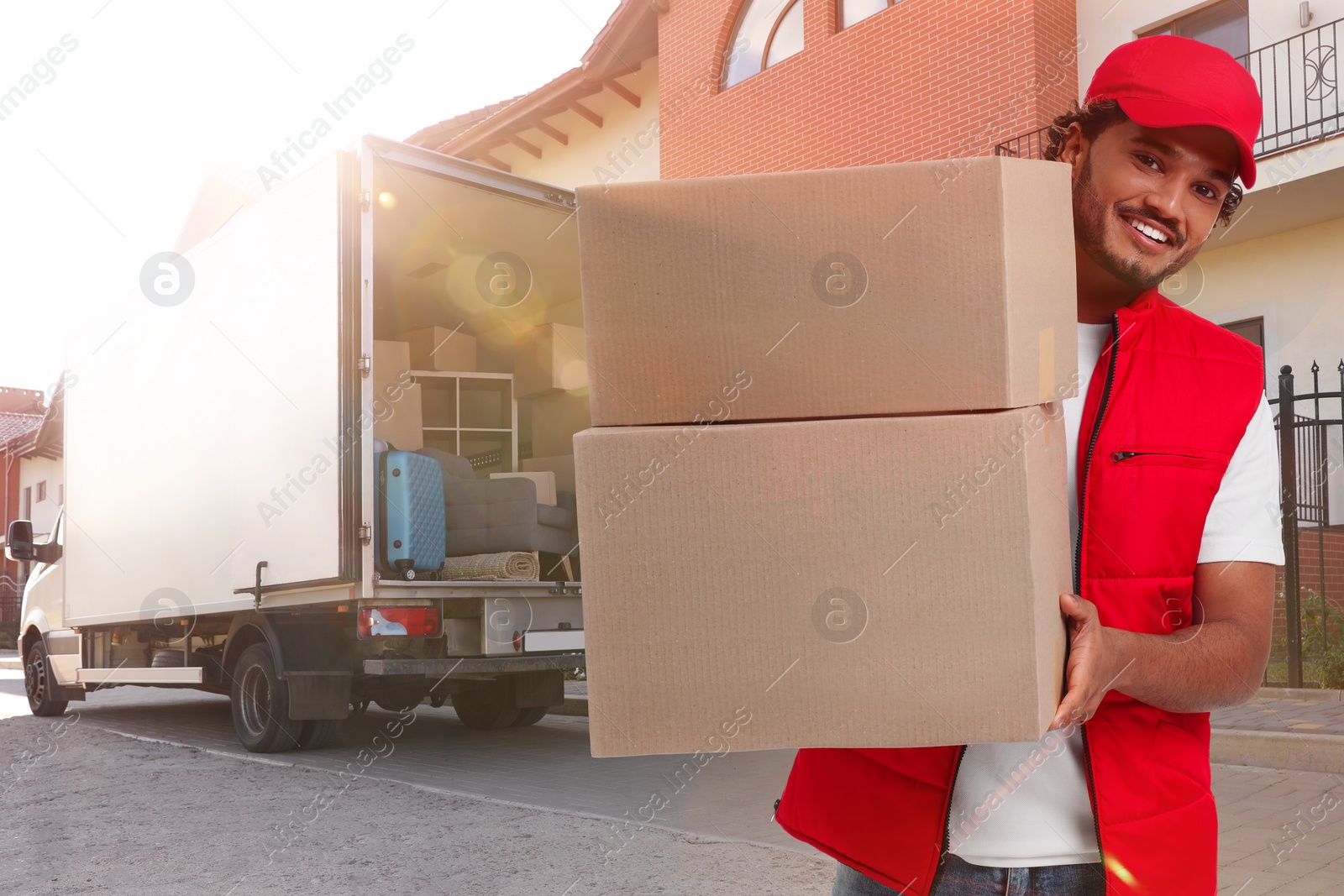 Image of Happy courier with parcels outdoors, space for text