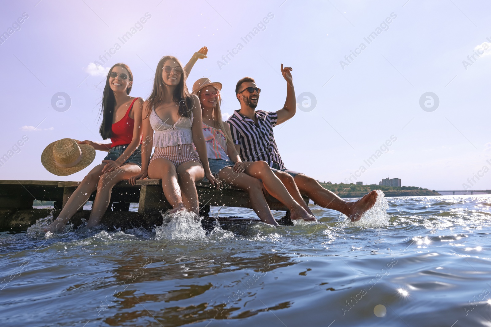 Photo of Group of friends having fun near river at summer party