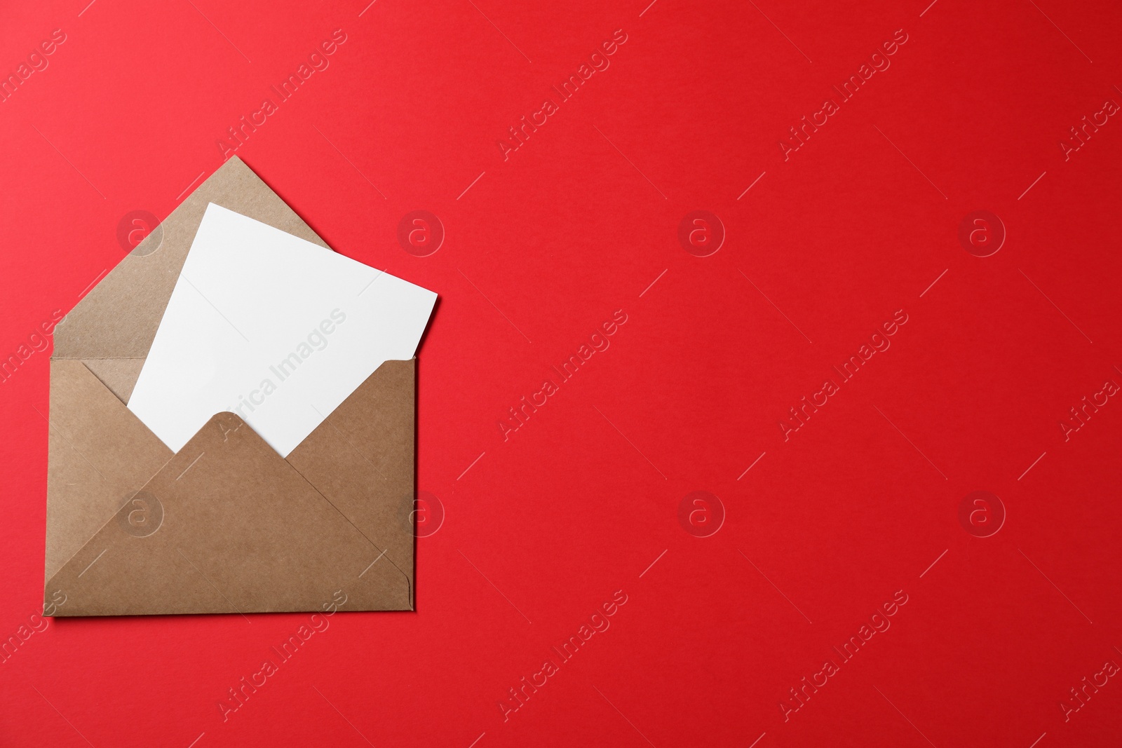 Photo of Letter envelope with card on red background, top view. Space for text