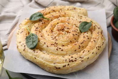 Photo of Delicious puff pastry with spinach on grey table, closeup