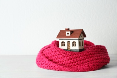 Photo of House model and scarf table against white background. Heating efficiency