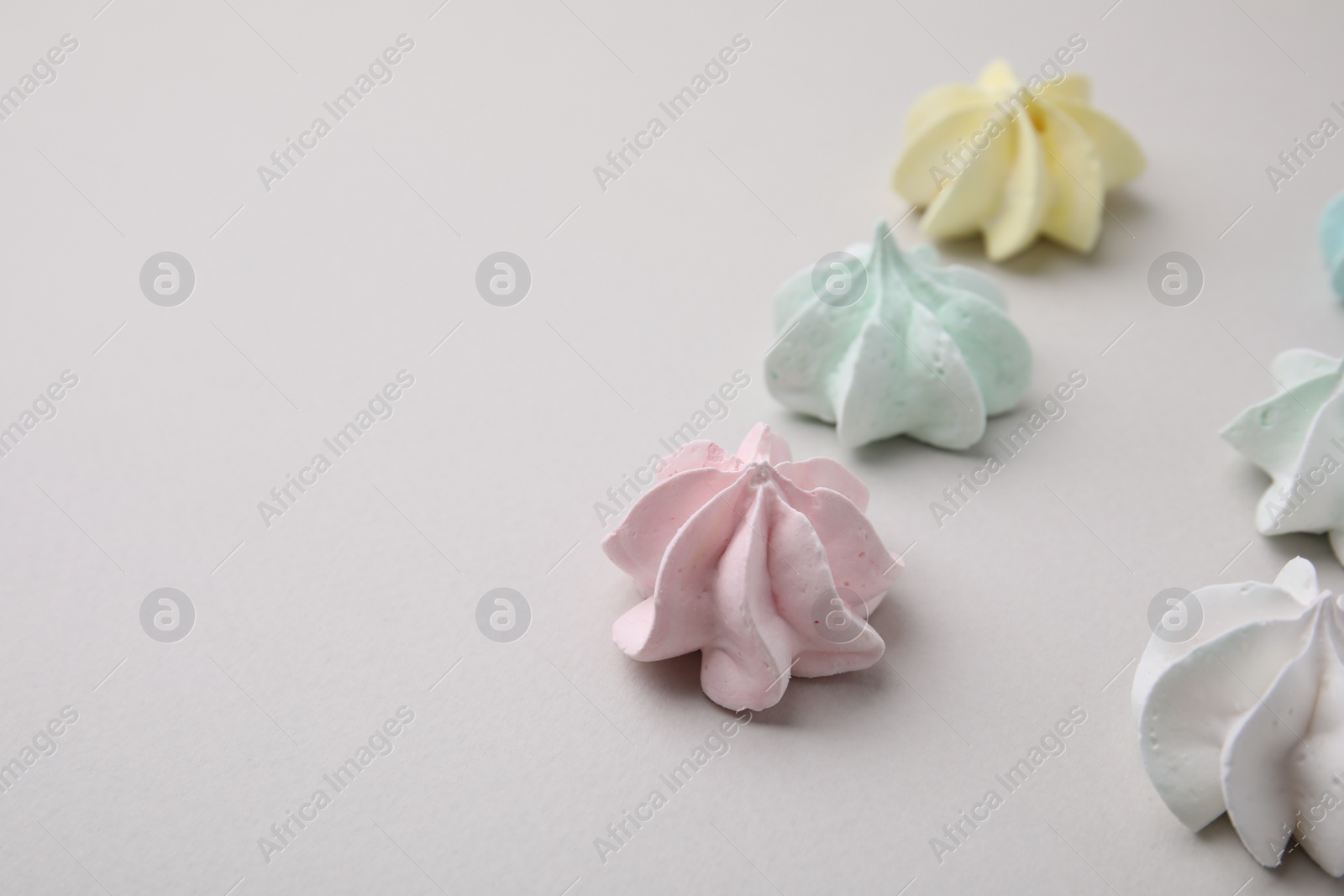 Photo of Delicious meringue cookies on light background, closeup. Space for text