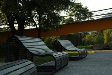 Photo of Beautiful wooden benches in park near trees