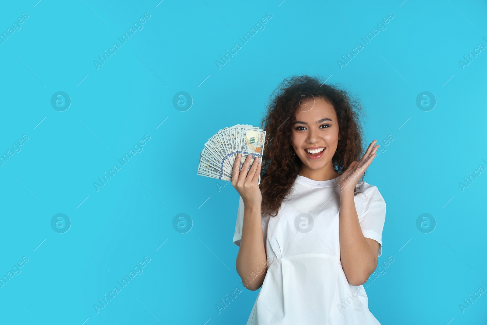 Photo of Young African-American woman with money on color background. Space for text