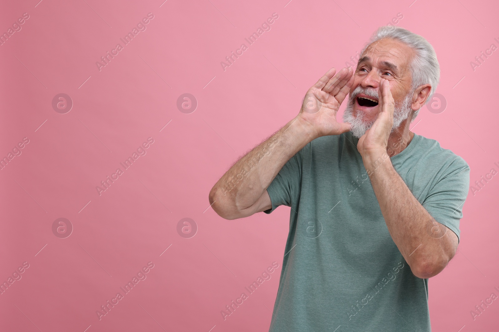 Photo of Special promotion. Senior man shouting to announce information on pink background. Space for text