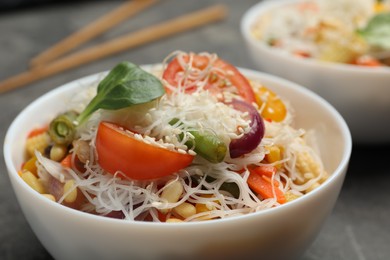 Tasty cooked rice noodles with vegetables on table, closeup