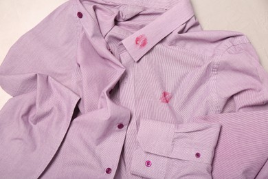 Photo of Men's shirt with lipstick kiss marks on light background, closeup